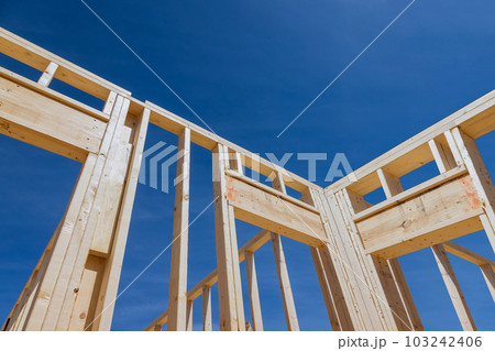 Frame house constructed from wooden beams sticks on new construction project Frame house constructed from wooden beams sticks on new construction project 103242406