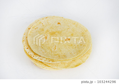 Top down view of a stack of 20 flour tortillas pre grilled on white background 103244296