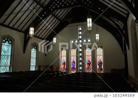 Church pews, hanging chandeliers, demon, creepy, stained glass religious windows depicting saints Church pews, hanging chandeliers, demon, creepy, stained glass religious windows depicting saints 103244569
