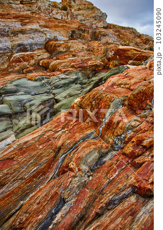 Rock layers cover coast of Maine with orange layers and quarter veins Rock layers cover coast of Maine with orange layers and quarter veins 103245090