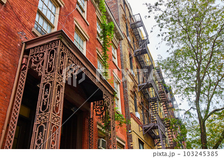 Stunning brick building with vines and metal entrance from angle Stunning brick building with vines and metal entrance from angle 103245385