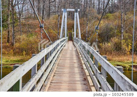 Looking down large suspension bridge over river in Michigan park Looking down large suspension bridge over river in Michigan park 103245589