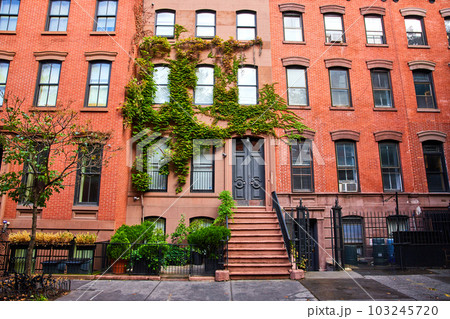 View outside beautiful apartment building with red bricks and green vines in Greenwich Village New York City 103245720