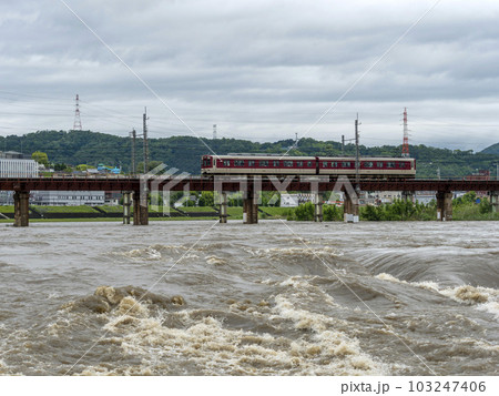 豪雨で増水した河川を渡る電車 豪雨で増水した河川を渡る電車 103247406