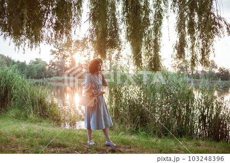 A young woman going on a picnic in a park 103248396