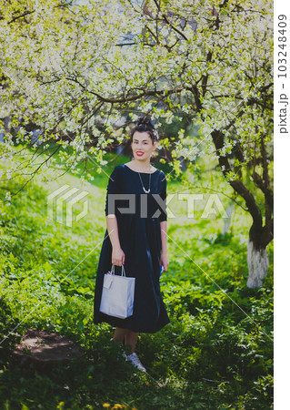 Happy woman walking in the spring cherry garden Happy woman walking in the spring cherry garden 103248409