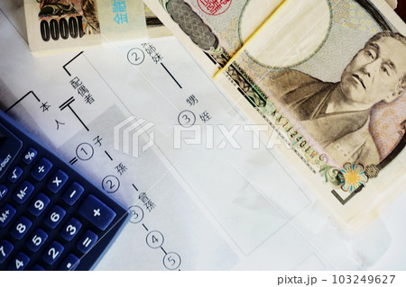 等親図の上に置かれた一万円札と電卓、相続イメージ 103249627