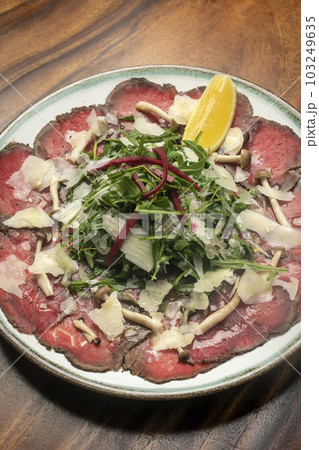 beef Carpaccio with salad and parmesan cheese 103249635