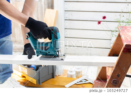 ベランダでDIYに精を出す男性 ベランダでDIYに精を出す男性 103249727