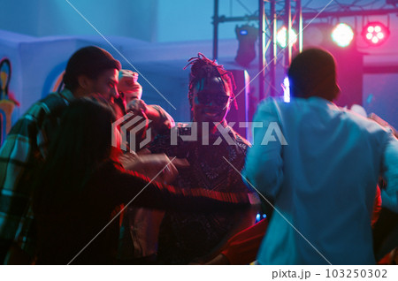 Diverse people waltzing in nightclub, attending cool party with friends at discotheque. Young couples dancing in pairs on romantic music, showing off slow dance moves on dance floor. Tripod shot. Diverse people waltzing in nightclub, attending cool party with friends at discotheque. Young couples dancing in pairs on romantic music, showing off slow dance moves on dance floor. Tripod shot. 103250302