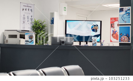 Empty chairs in hospital reception lobby, medical leaflets and forms on table to use before health care appointments. Waiting area seats in diagnostic center, clinical service. Empty chairs in hospital reception lobby, medical leaflets and forms on table to use before health care appointments. Waiting area seats in diagnostic center, clinical service. 103251233