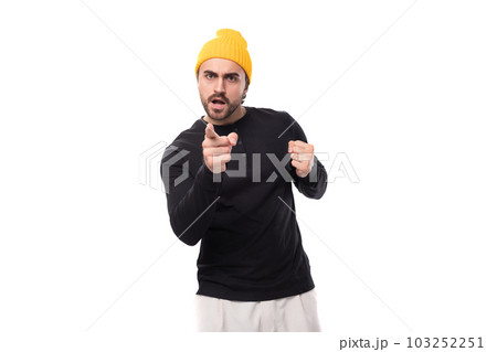 young stylish brunette european brutal man in a black sweatshirt demonstrates an idea 103252251