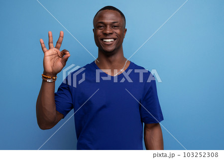 handsome friendly young african man in blue t-shirt smiling 103252308