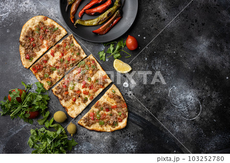 Turkish pide with minced meat, Kiymali Pide, on black dark stone table background, top view flat lay, with copy space for text 103252780