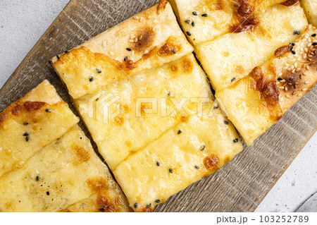Turkish Cuisine baked dish pide, on gray concrete table background, close up macro, top view flat lay Turkish Cuisine baked dish pide, on gray concrete table background, close up macro, top view flat lay 103252789