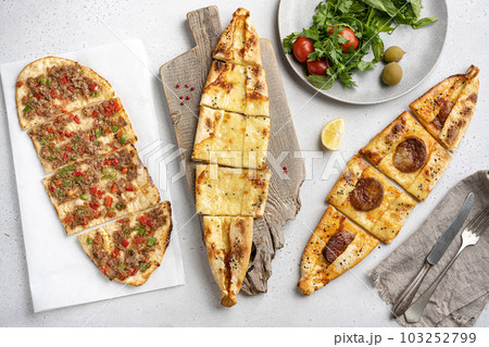 Assorted Kasarli Kiymali sucuklu  pide Turkish dish, on gray concrete table background, on gray concrete table background, top view flat lay 103252799
