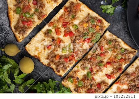 Dish pita precious Kiymali Pide, on black dark stone table background, top view flat lay 103252811