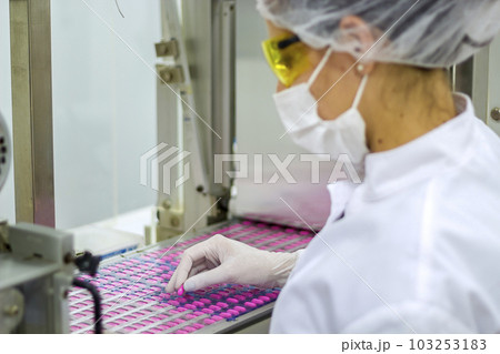Pharmaceutical Quality Control Worker Oversees the Packaging of the Medical pills at Production Line 103253183