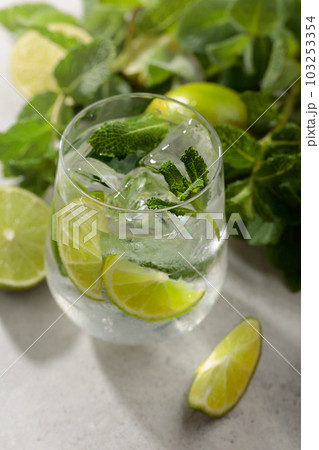 Mojito with ice, lime, and mint on a white stone table. 103253354