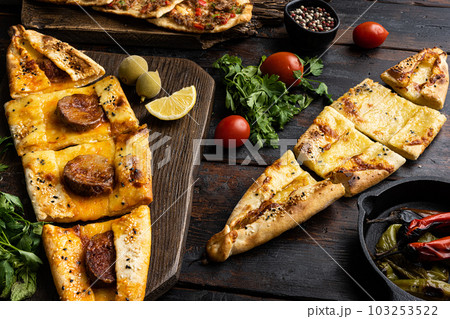 Three Pides of cheese, meat and bacon Traditional Turkish cuisine, on gray concrete table background, on old dark wooden table background Three Pides of cheese, meat and bacon Traditional Turkish cuisine, on gray concrete table background, on old dark wooden table background 103253522