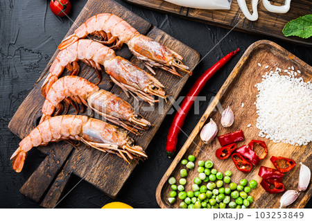 Traditional valenciana paella seafood ingredients with prawns, mussels, rice and spices on black concrete surface, flat lay Traditional valenciana paella seafood ingredients with prawns, mussels, rice and spices on black concrete surface, flat lay 103253849