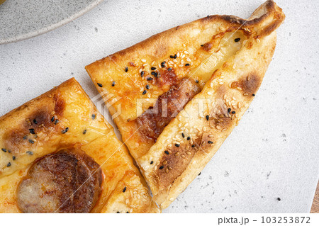 Pide dish with slices of pepperoni and cheese, on gray concrete table background, close up macro, top view flat lay, with copy space for text Pide dish with slices of pepperoni and cheese, on gray concrete table background, close up macro, top view flat lay, with copy space for text 103253872