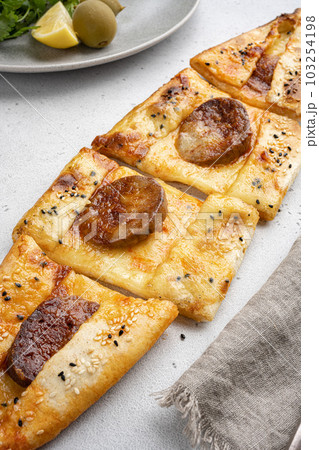 Turkish traditional sucuklu pide with pepperoni, on gray concrete table background Turkish traditional sucuklu pide with pepperoni, on gray concrete table background 103254198