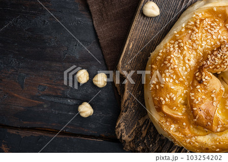 Burekas filled with cheese painir , on old dark  wooden table background, top view flat lay, with copy space for text 103254202