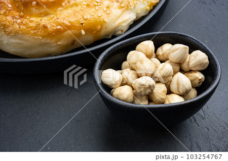 Nuts in bowl, on black dark stone table background, with copy space for text 103254767