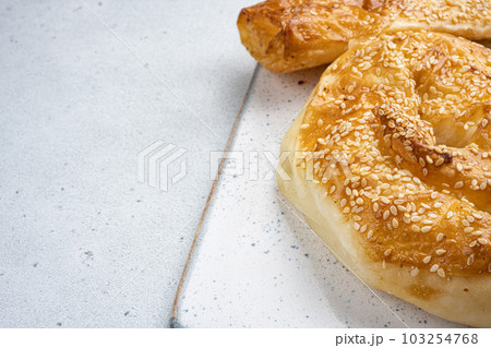 Burekas filled with cheese painir , on gray concrete table background, with copy space for text 103254768