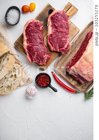 Strip loin steak, raw marbled meat, on white background, top view, with copy space for text 103255278