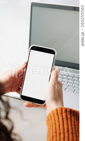 Modern Woman Using Smartphone with Blank Screen for Apps or E-Learning in Over Shoulder View 103255501