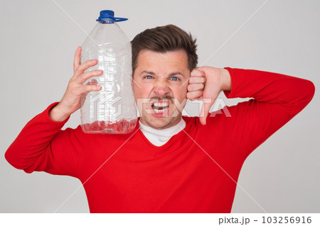 Caucasian man holding empty plastic bottle. Problem with frinking pure water. Caucasian man holding empty plastic bottle. Problem with frinking pure water. 103256916