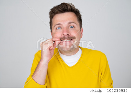 Young handsome man shut mouth and lups as zip with fingers 103256933