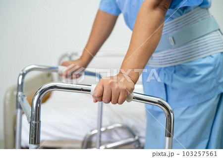 Asian lady patient use walker in hospital to support walking. 103257561