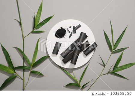 Organic activated charcoal put on white podium in round-shaped. Cosmetic product extracted from activated bamboo charcoal can treat acne Organic activated charcoal put on white podium in round-shaped. Cosmetic product extracted from activated bamboo charcoal can treat acne 103258350
