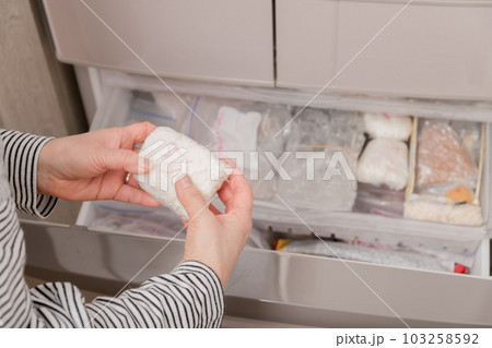 【冷凍室から冷凍ごはんを出す主婦】 【冷凍室から冷凍ごはんを出す主婦】 103258592