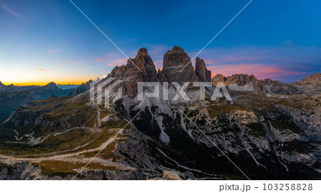 Edges of high peaks after sunset. Tre Chime di Lavaredo under a bright sky, an aerial view 103258828