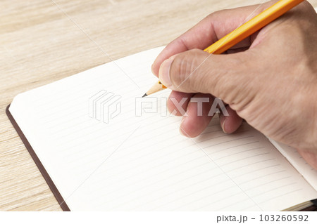 手帳に書き込みをする手元 103260592