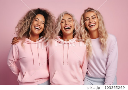Three female friends in wearing sport clothes, laughing happily on pink background. Generative Ai 103265269