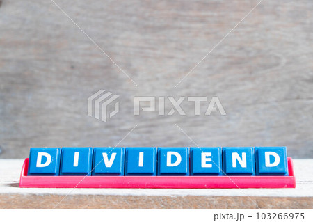 Tile alphabet letter with word dividend in red color rack on wood background 103266975