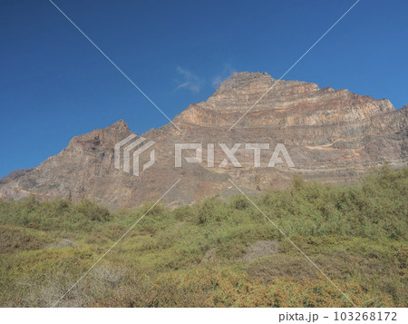 Scenic view on pink massive sharp cliffs and mountain Tequergenche in the La Mercia mountain range in Valle Gran Rey, La Gomera, Canary Islands, Spain, Europe. Blue sky background copy space. 103268172