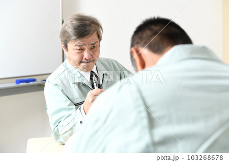 部下に注意をする作業服を着た中高年の男性 部下に注意をする作業服を着た中高年の男性 103268678