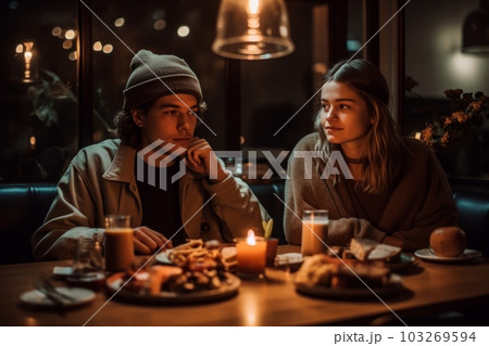 A laid-back couple, sitting under string lights eating avocado toast and smoothies. Concept nostalgic, grammable millennial moment. Generative AI 103269594