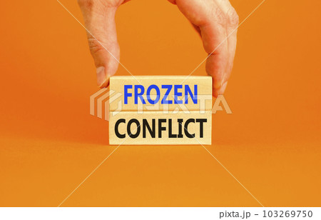 Frozen conflict symbol. Concept words Frozen conflict on beautiful wooden block. Beautiful orange table orange background. Businessman hand. Business and Frozen conflict concept. Copy space. Frozen conflict symbol. Concept words Frozen conflict on beautiful wooden block. Beautiful orange table orange background. Businessman hand. Business and Frozen conflict concept. Copy space. 103269750