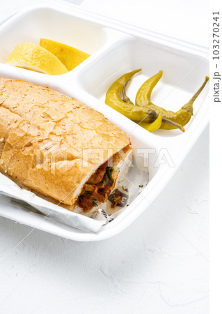 Chicken tantuni kebab Somun ekmek tavuk, in plastic pack container delivery lunch box, on white stone table background Chicken tantuni kebab Somun ekmek tavuk, in plastic pack container delivery lunch box, on white stone table background 103270241