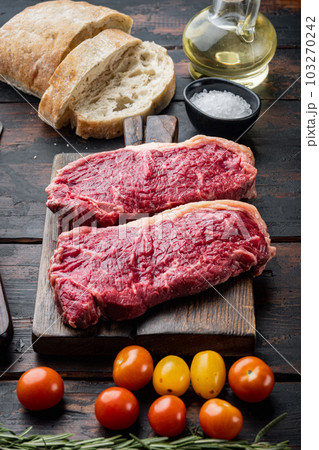 Raw beef steak burger ingredients with marbled meat, on old wooden table 103270242