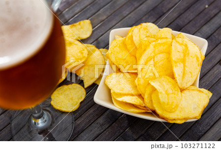Chips served as snack food with beer Chips served as snack food with beer 103271122