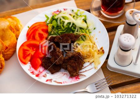Grilled Turkish kofte from lamb with vegetable garnish Grilled Turkish kofte from lamb with vegetable garnish 103271322
