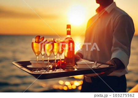 Waiter Serving Champagne Glasses on Tray at Summer Beach Sunset Background. Generative ai Waiter Serving Champagne Glasses on Tray at Summer Beach Sunset Background. Generative ai 103275562